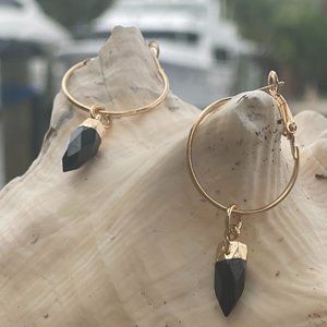 Obsidian prism point gem on gold hoop earing.